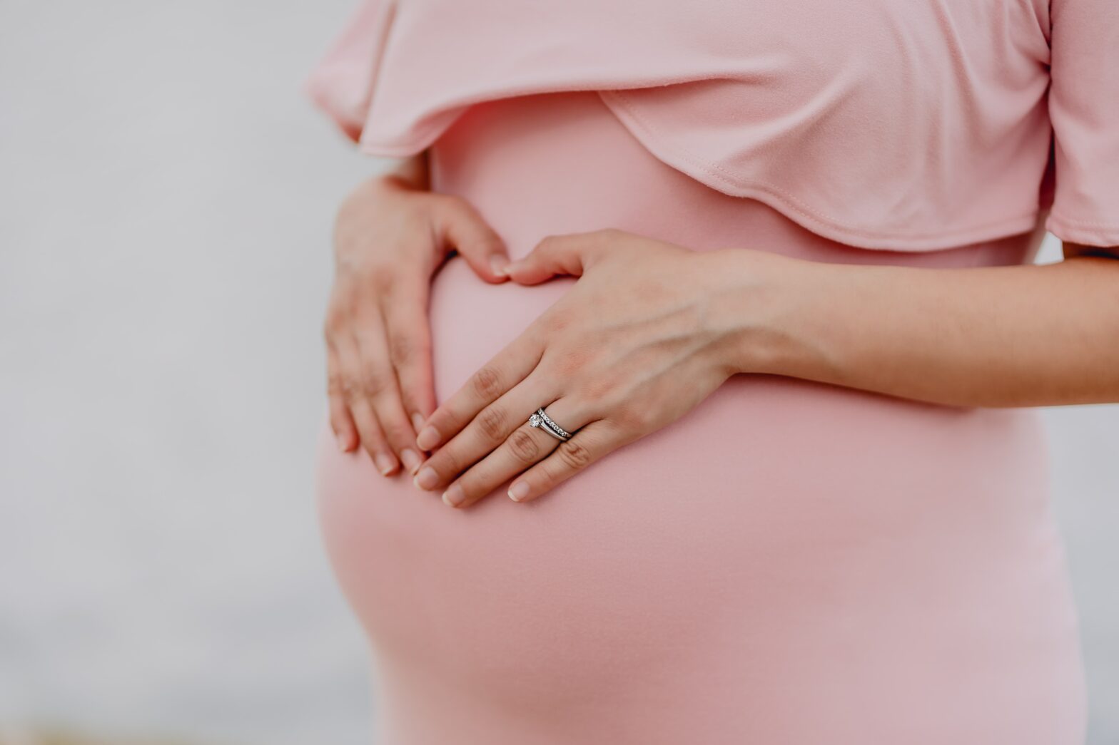 A woman holding her stomach during pregnancy.